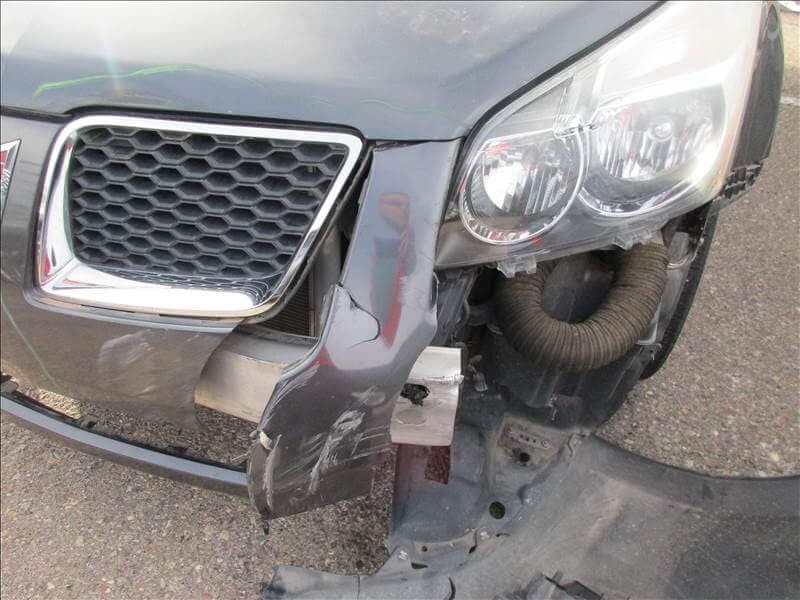 Pontiac Vibe with smashed front bumper and exposed grille before bodywork